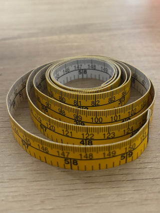 Roll of measuring tape on a wooden surface